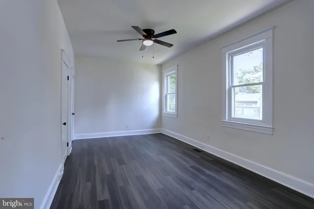 a view of wooden floor and a chandelier fan in a room