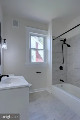 a bathroom with a toilet a sink a vanity and mirror