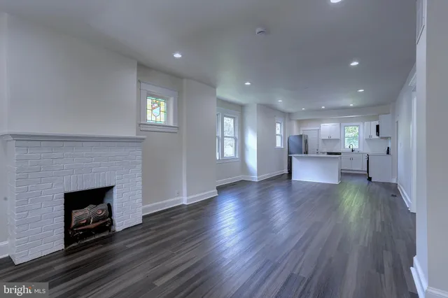 an empty room with wooden floor and fireplace