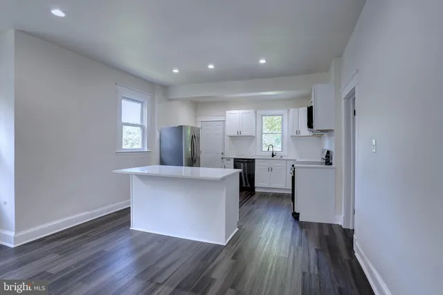 a kitchen with kitchen island a sink appliances and cabinets