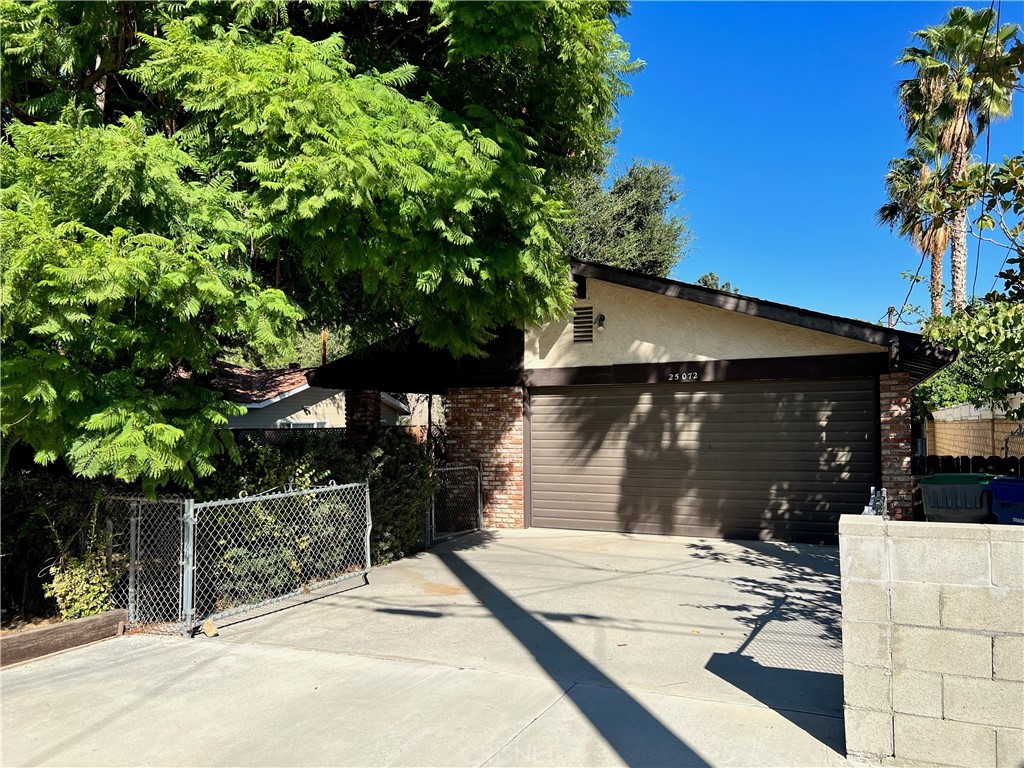 a view of house with backyard space and potted plants