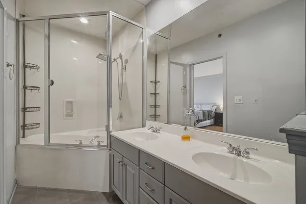a bathroom with a double vanity sink mirror double and shower