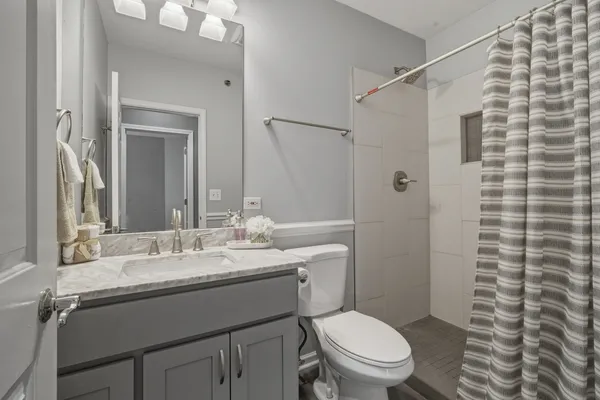 a bathroom with a granite countertop sink toilet a mirror and shower