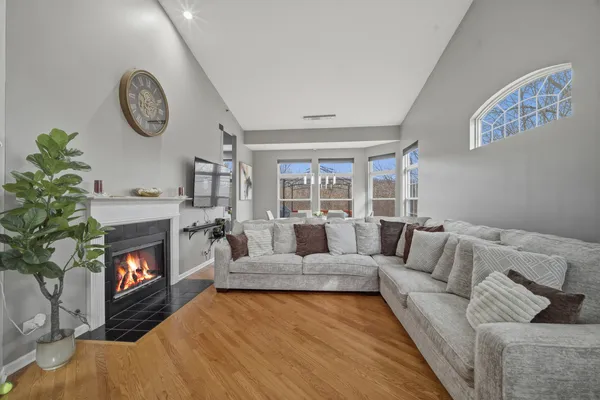 a living room with furniture a fireplace and a large window