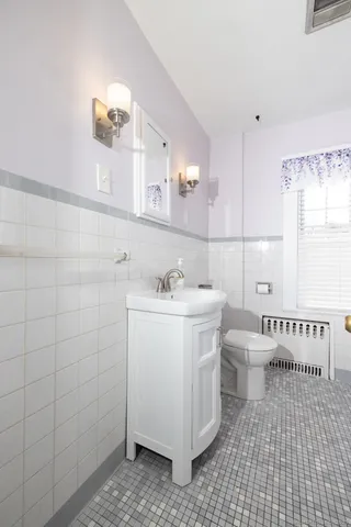 a bathroom with a sink a toilet and mirror