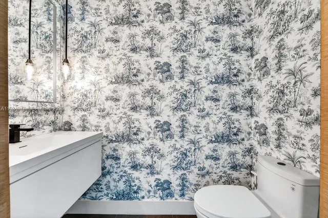 a bathroom with a granite countertop toilet and a sink