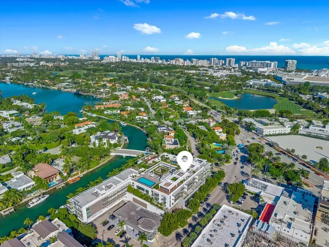 an aerial view of a city with lots of residential buildings ocean and mountain view in back