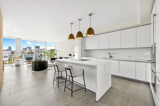 a kitchen with stainless steel appliances kitchen island granite countertop a table and chairs in it