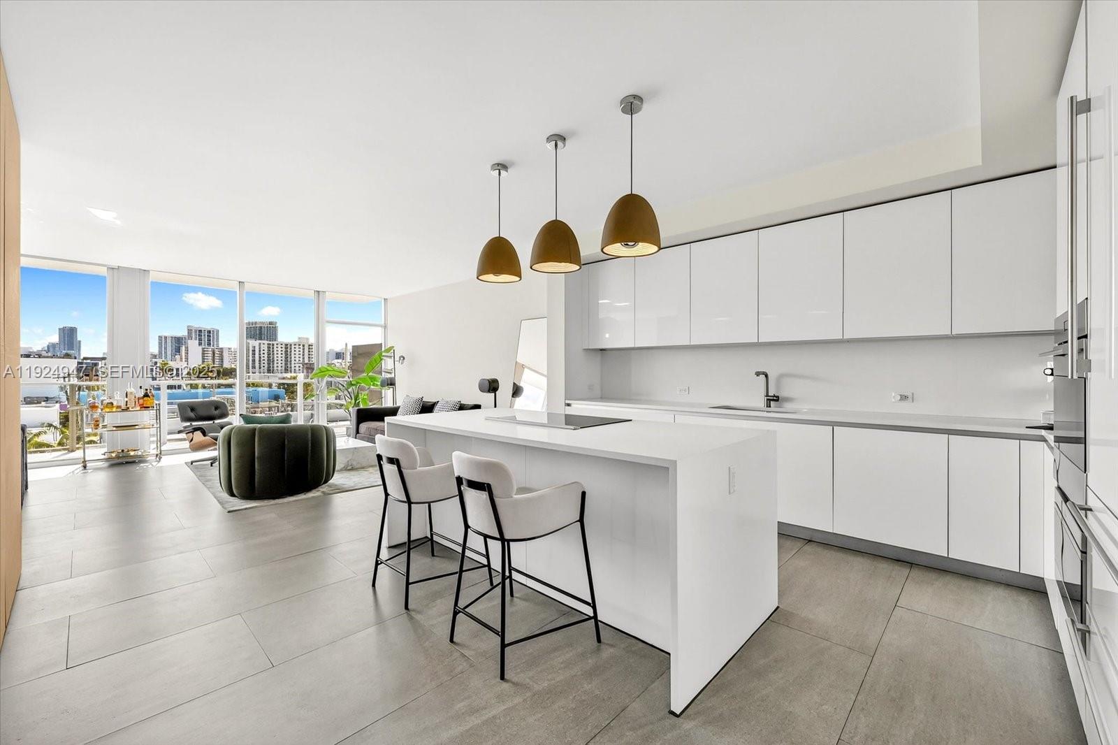 1201 20th Street, Unit PH07 Miami Beach, FL 33139 - Photo 7 of 30 a kitchen with stainless steel appliances kitchen island granite countertop a table and chairs in it