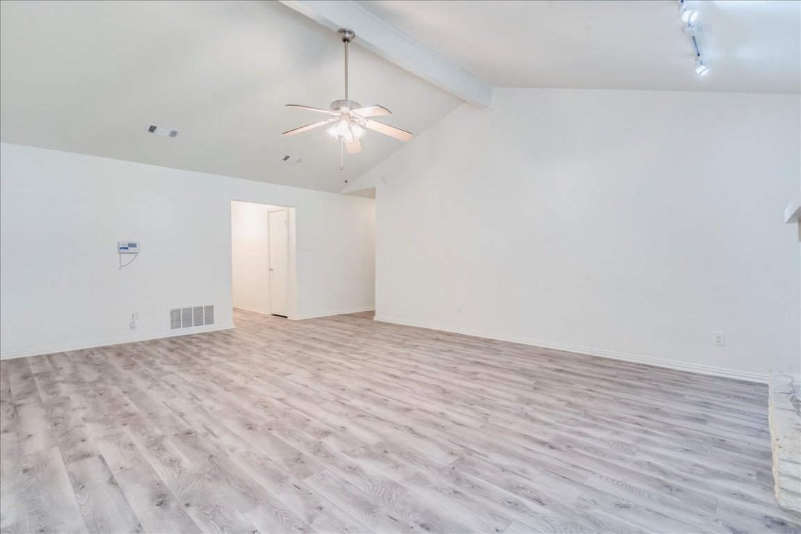 706 Windsor Road Round Rock, TX 78664 - Photo 9 of 29 an empty room with wooden floor and ceiling fan