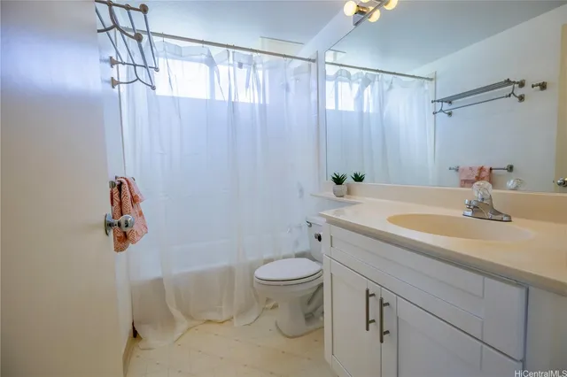 a bathroom with a sink a toilet and shower curtain