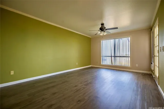 a view of a room with wooden floor a ceiling fan and windows