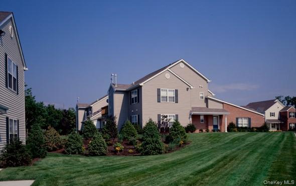 36 Neal Path, Unit 36 Centereach, NY 11720 - Photo 3 of 13 a front view of a house with a yard and trees