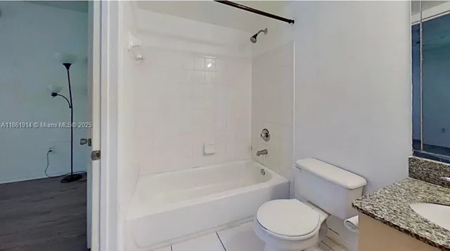 a white toilet sitting next to a bath tub
