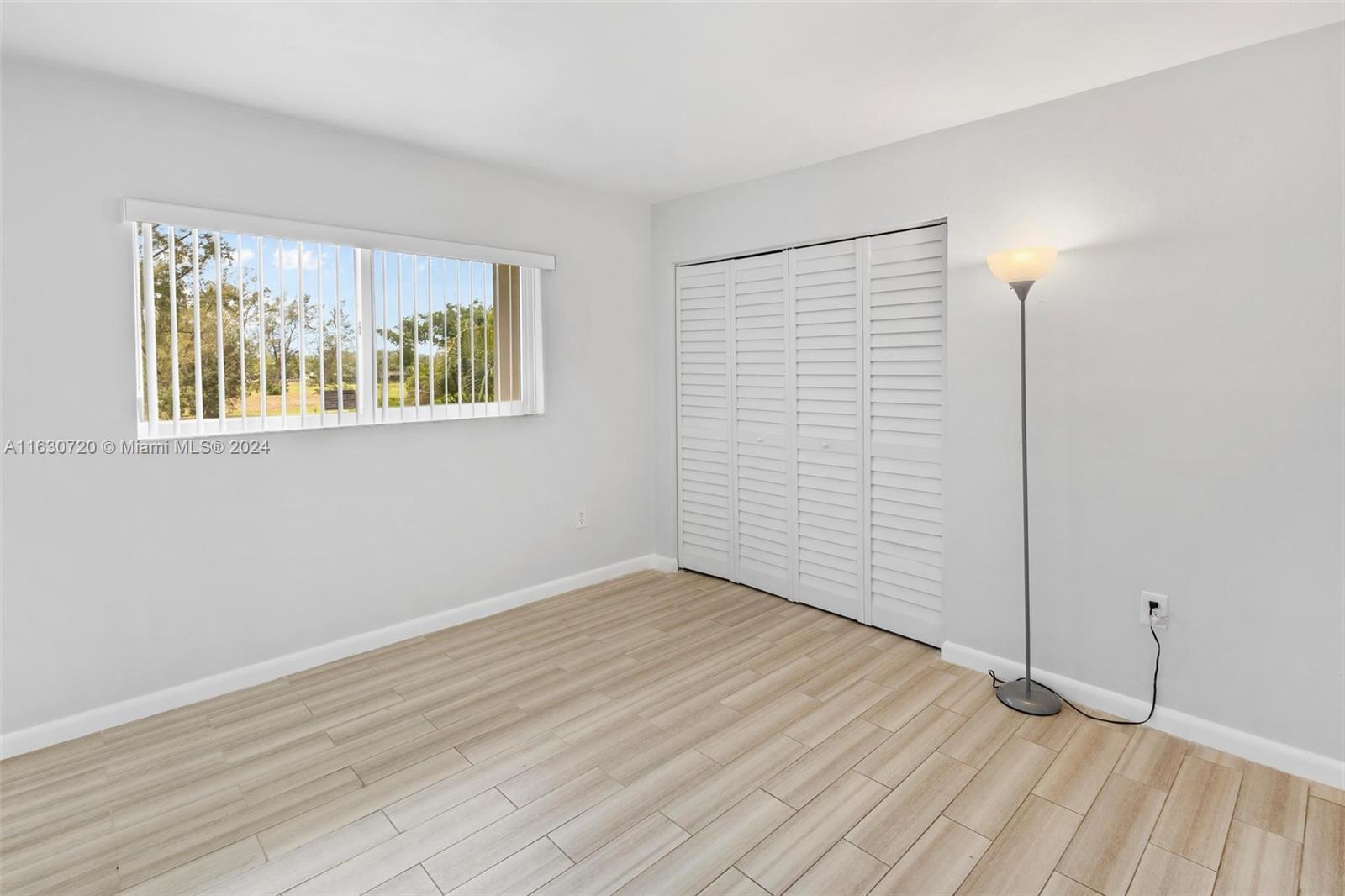 7430 Miami Lakes Drive, Unit E302 Miami Lakes, FL 33014 - Photo 11 of 29 a view of an empty room with wooden floor and a window