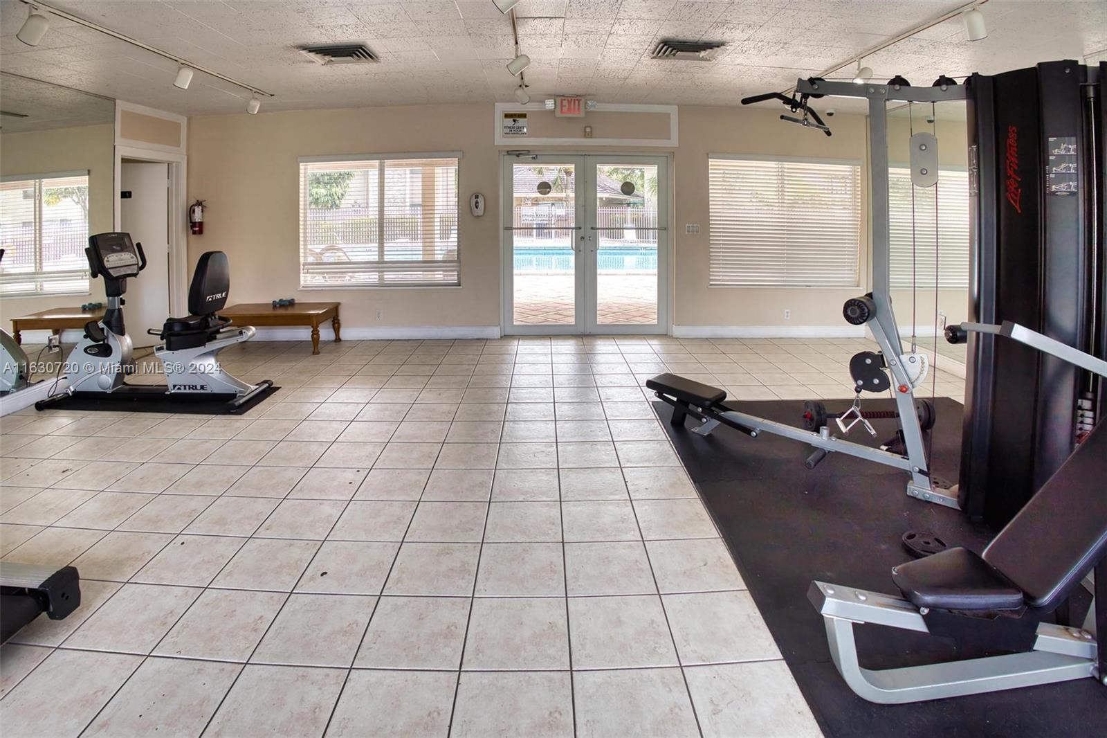 7430 Miami Lakes Drive, Unit E302 Miami Lakes, FL 33014 - Photo 26 of 29 a room with gym equipment and a large window