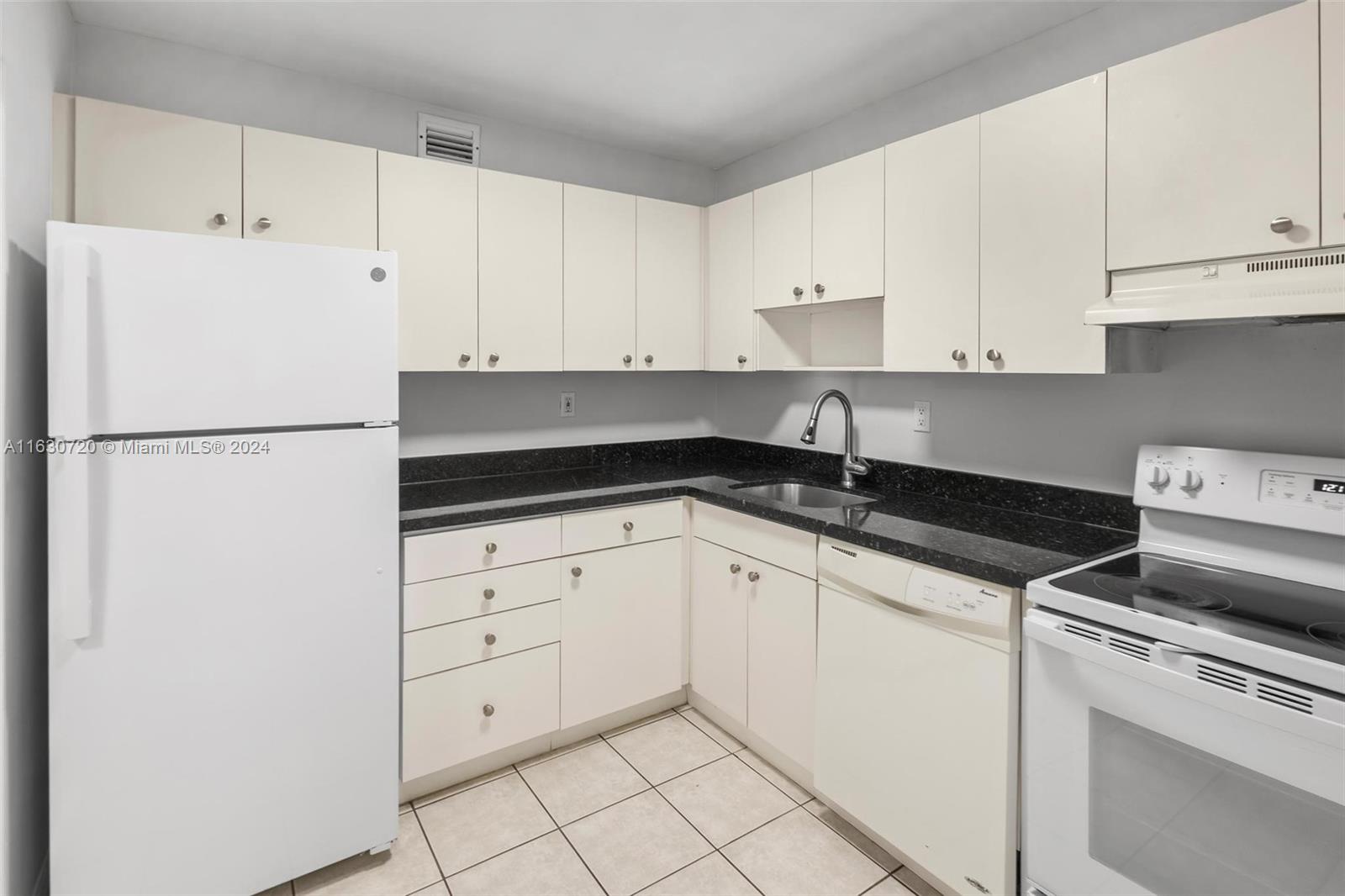 7430 Miami Lakes Drive, Unit E302 Miami Lakes, FL 33014 - Photo 4 of 29 a kitchen with white cabinets and white appliances