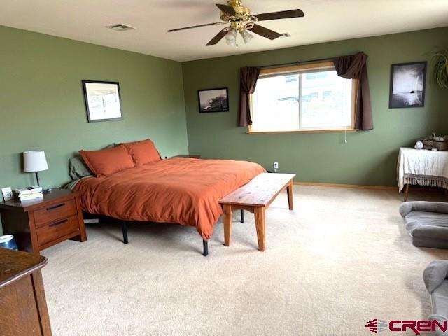 30022 Rd L Mancos, CO 81328 - Photo 8 of 16 a bedroom with a bed and a chandelier