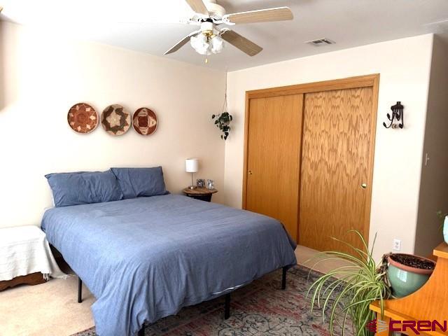 30022 Rd L Mancos, CO 81328 - Photo 9 of 16 a bedroom with a bed and a chandelier