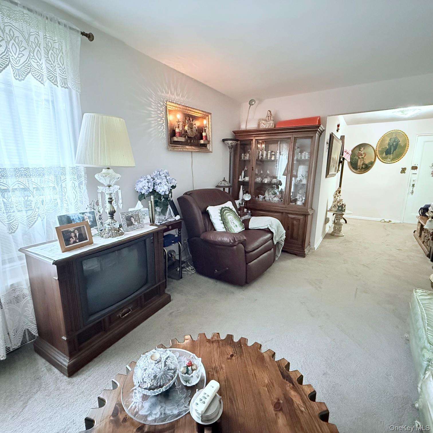 83-15 98th Street, Unit 3K Queens, NY 11421 - Photo 2 of 8 a living room with furniture and a flat screen tv