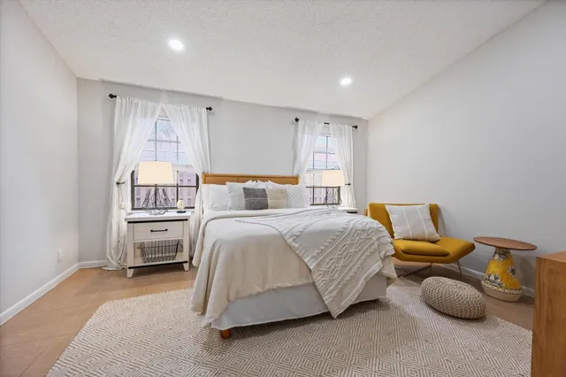 a bedroom with a bed and a refrigerator