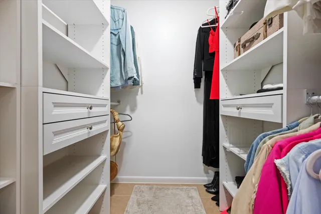 a view of walk in closet with clothes and shoes