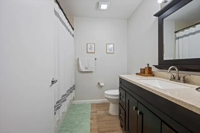 a bathroom with a granite countertop sink toilet and a mirror