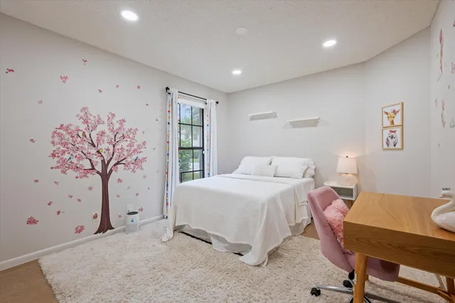 a bedroom with a large bed and a chandelier