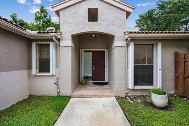 a front view of a house with potted plants