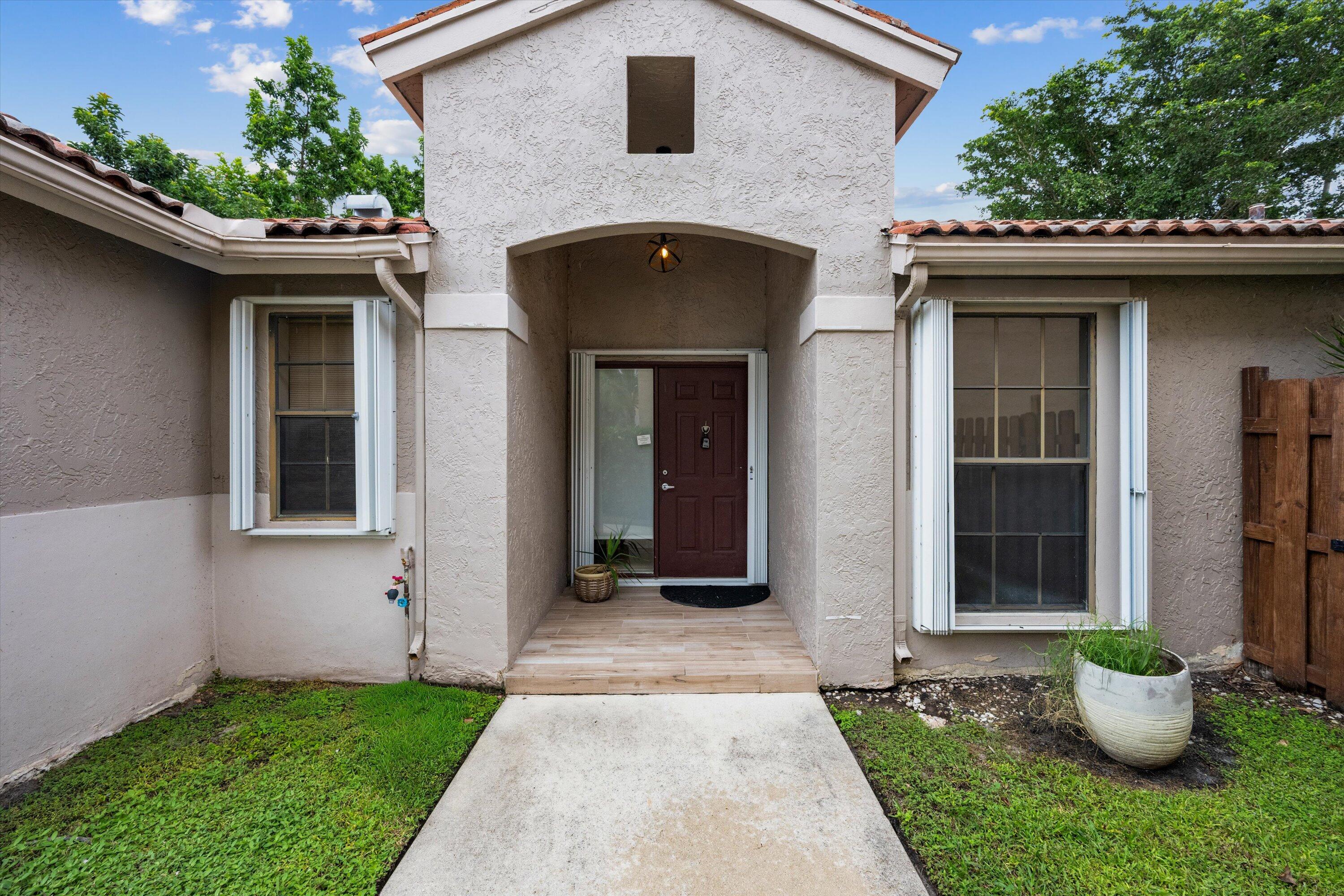 1769 Harborside Circle Wellington, FL 33414 - Photo 34 of 34 a front view of a house with potted plants