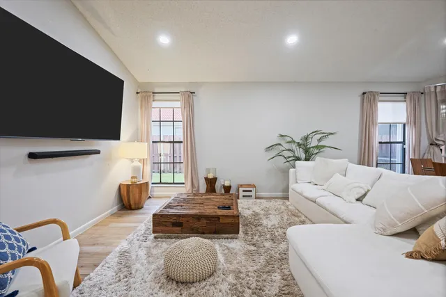 a living room with furniture a flat screen tv and a window