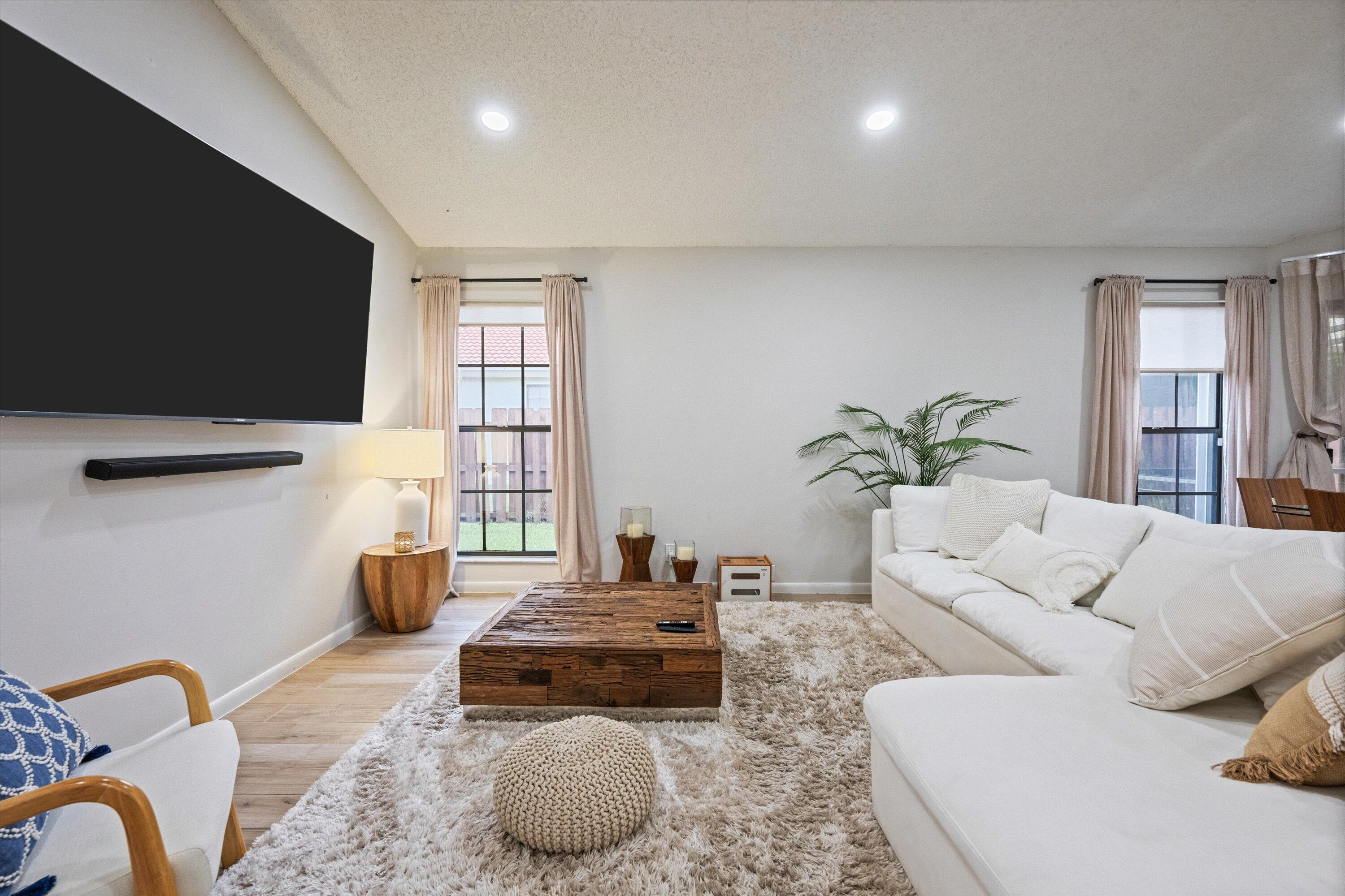 1769 Harborside Circle Wellington, FL 33414 - Photo 6 of 34 a living room with furniture a flat screen tv and a window