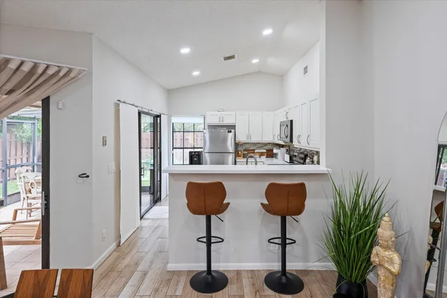 a kitchen with granite countertop a counter space dining table and chairs