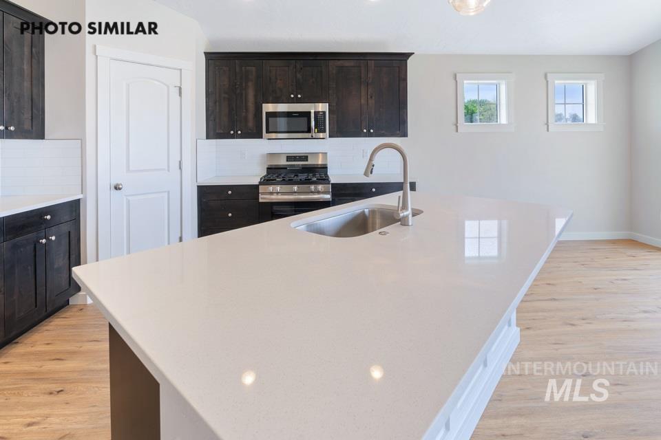 1708 Rapid Road Emmett, ID 83617 - Photo 15 of 33 Kitchen island with a light-toned countertop, integrated stainless steel sink, and gooseneck faucet