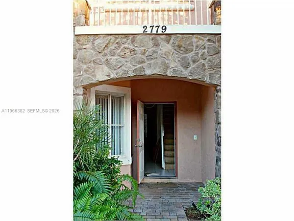a front view of a house with plants