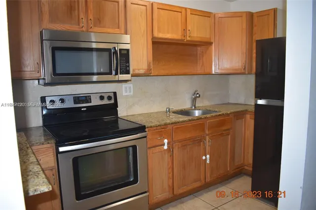 a kitchen with stainless steel appliances a stove microwave and sink