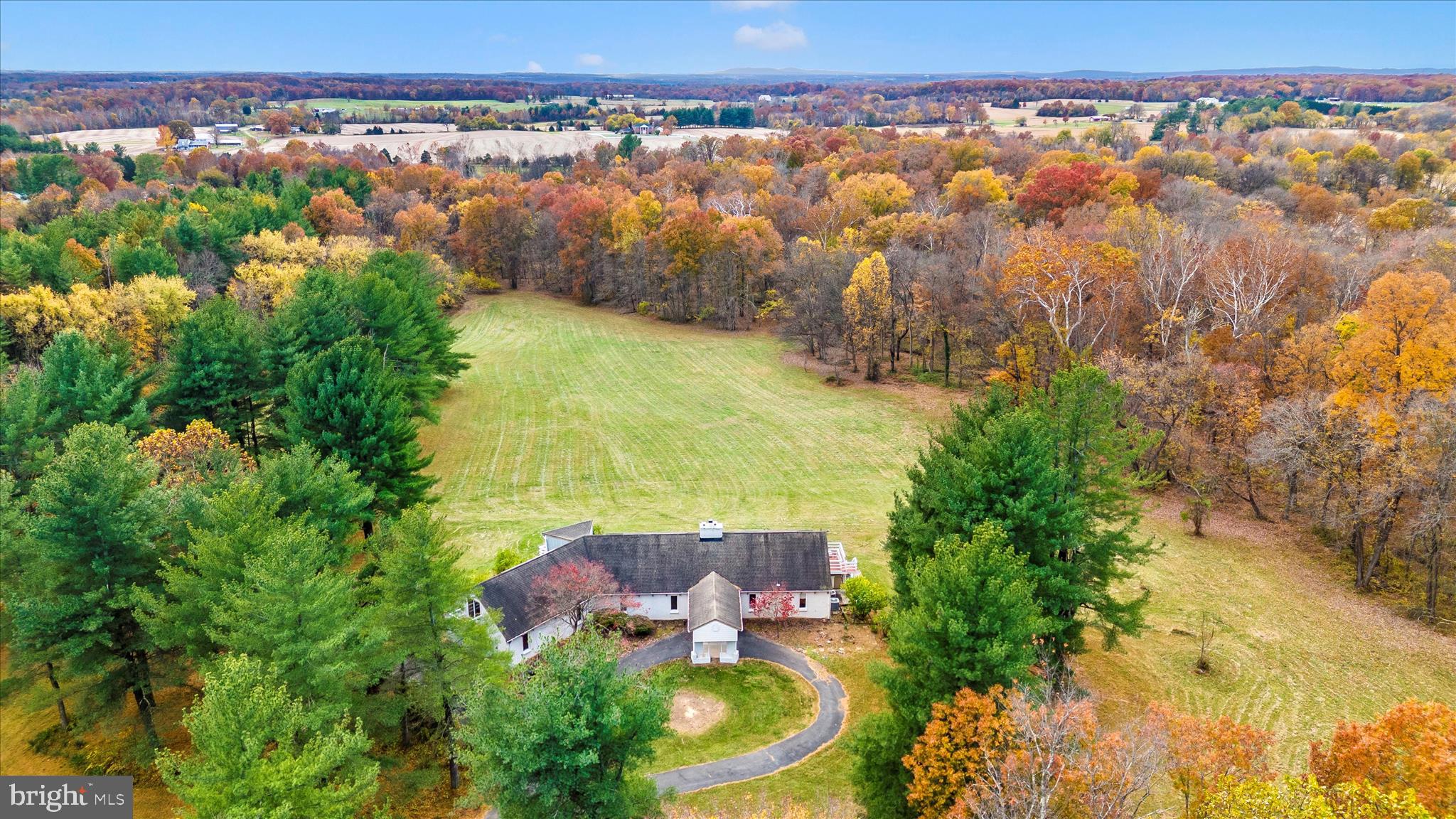 an aerial view of residential houses with outdoor space and trees