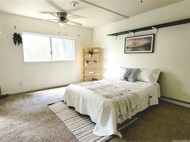 a bedroom with bed and paintings on the wall