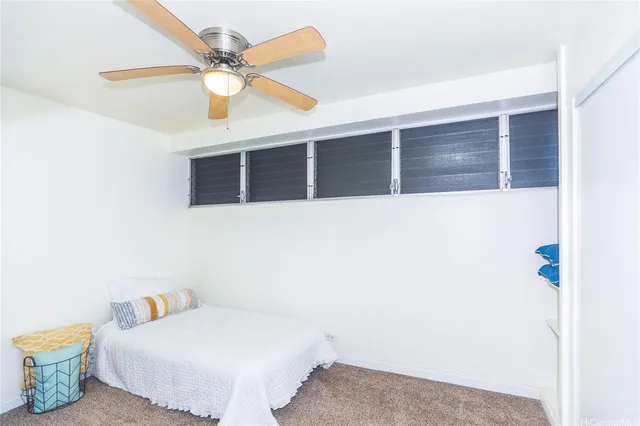 a bedroom with a bed and a ceiling fan