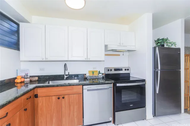 a kitchen with stainless steel appliances granite countertop a refrigerator a stove a sink and dishwasher