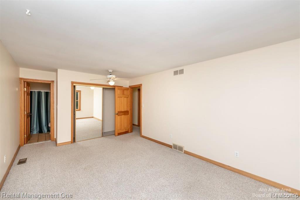 7870 Chamberlin Road Dexter, MI 48130 - Photo 23 of 52 Carpeting, wood-finish interior doors, a ceiling fan, and mirrored closet doors