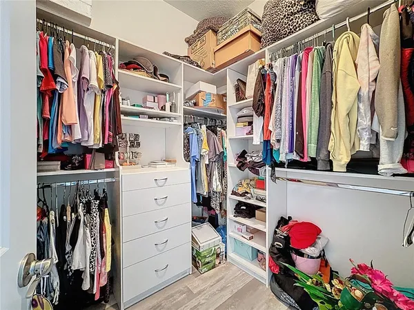 a view of walk in closet with clothes