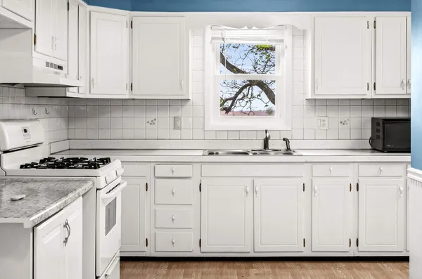 a kitchen with white cabinets and white appliances