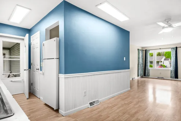 a view of a hallway with wooden floor and a living room