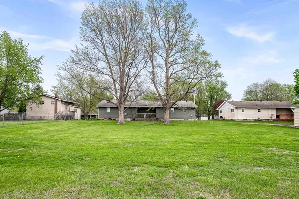 a front view of house with yard and tree in it