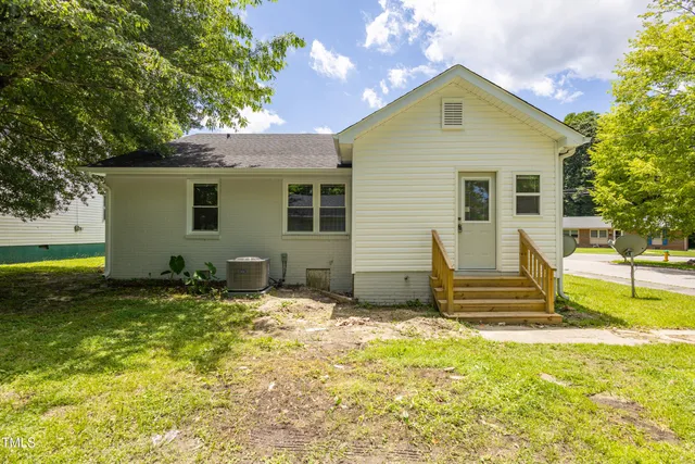 a backyard of a house with table and chairs
