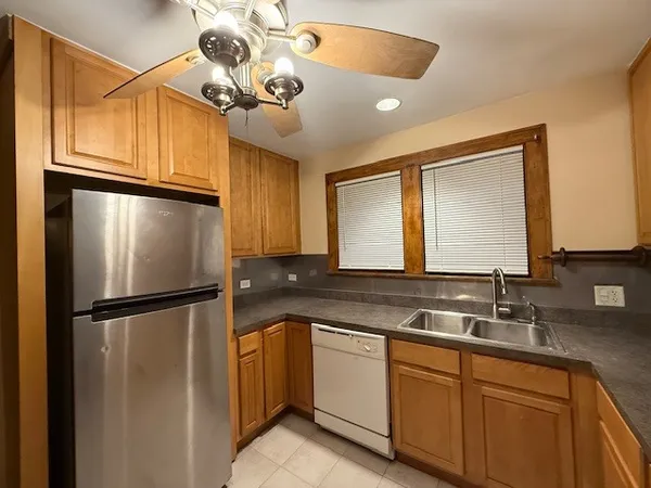 a kitchen with a refrigerator a sink and cabinets