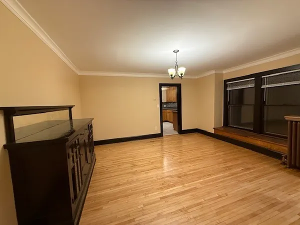 a view of empty room with wooden floor