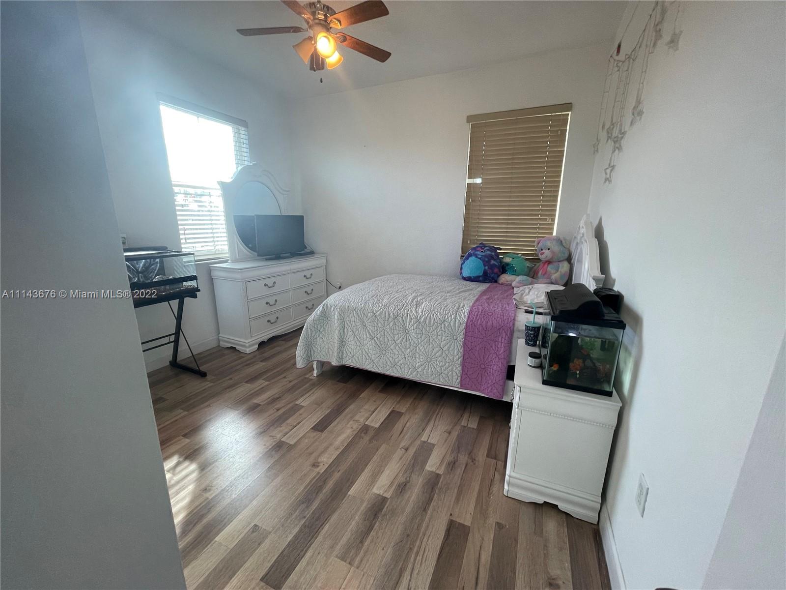 23744 Southwest 108th Court Homestead, FL 33032 - Photo 11 of 22 a bedroom with a bed and wooden floor