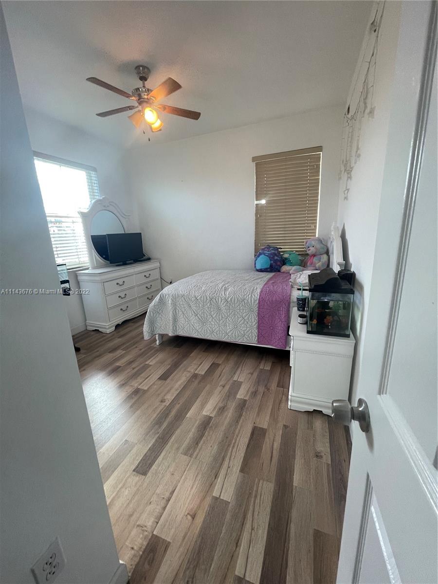 23744 Southwest 108th Court Homestead, FL 33032 - Photo 12 of 22 a bedroom with a bed and wooden floor
